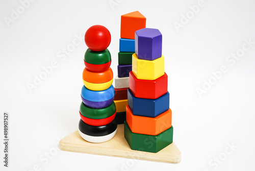 Wooden toy for baby, children isolated on white background. Towers with pieces of different colors and shapes.