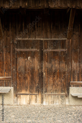 Closed wooden barn door of an old farm building, no people