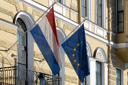 Фотография Flags of the European Union and the Netherlands hang on the facade of the embass