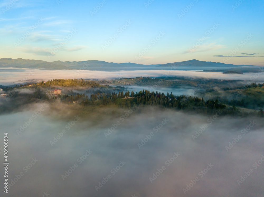 The rays of dawn over the fog in the Ukrainian Carpathians. Aerial drone view. The rays of dawn over the fog in the Ukrainian Carpathians. Aerial drone view.