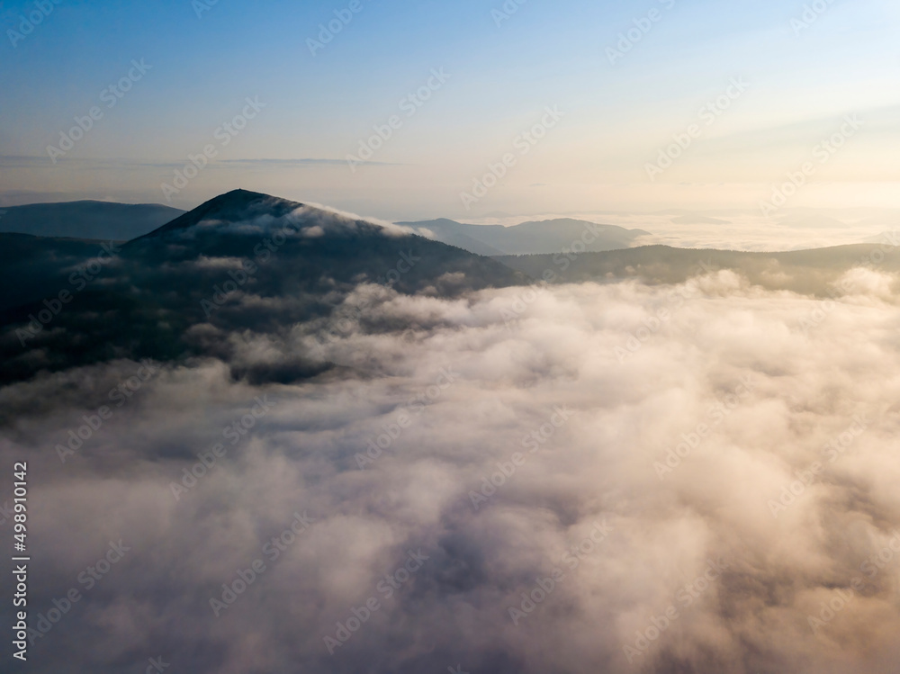 Flight over fog in Ukrainian Carpathians in summer. Mountains on the horizon. Aerial drone view. Flight over fog in Ukrainian Carpathians in summer. Mountains on the horizon. Aerial drone view.