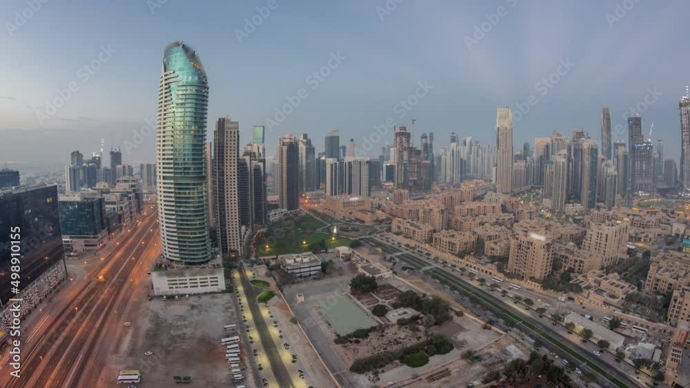 Dubai's business bay towers aerial night to day timelapse. Rooftop view of some skyscrapers