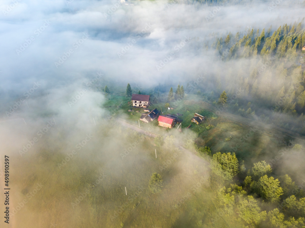 Fototapeta premium Mountain settlement in the Ukrainian Carpathians in the morning mist. Aerial drone view.