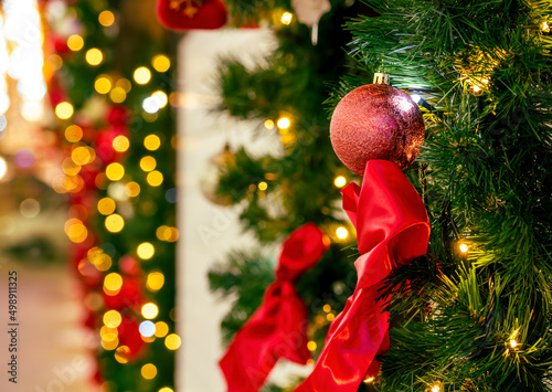 Christmas decoration with green fir tree branches and toys, colorful balls , soxes and red bows in outdoor decor with night city lights on background photo