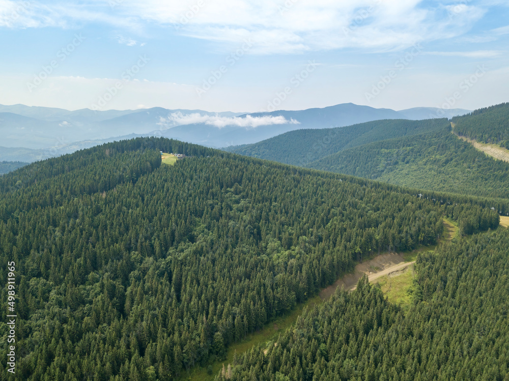 Green mountains of Ukrainian Carpathians in summer. Sunny day, rare clouds. Aerial drone view.