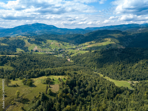 Green mountains of Ukrainian Carpathians in summer. Coniferous trees on the slopes. Aerial drone view.