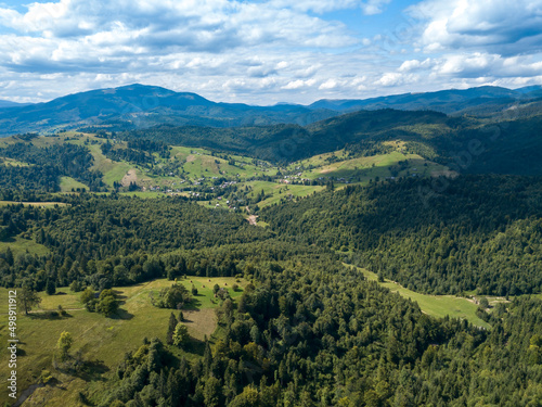 Green mountains of Ukrainian Carpathians in summer. Coniferous trees on the slopes. Aerial drone view. © Sergey