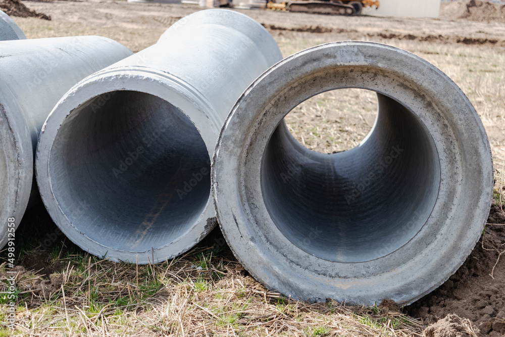 Reinforced concrete storm sewer pipes of large diameter stacked at a construction site. Sewer Large diameter pipes. Wastewater disposal in a modern city.