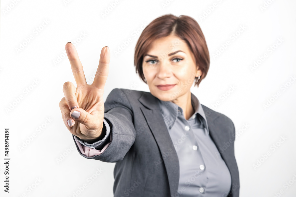 Business woman in suit shows victory sign with hand Business woman in suit shows victory sign with hand