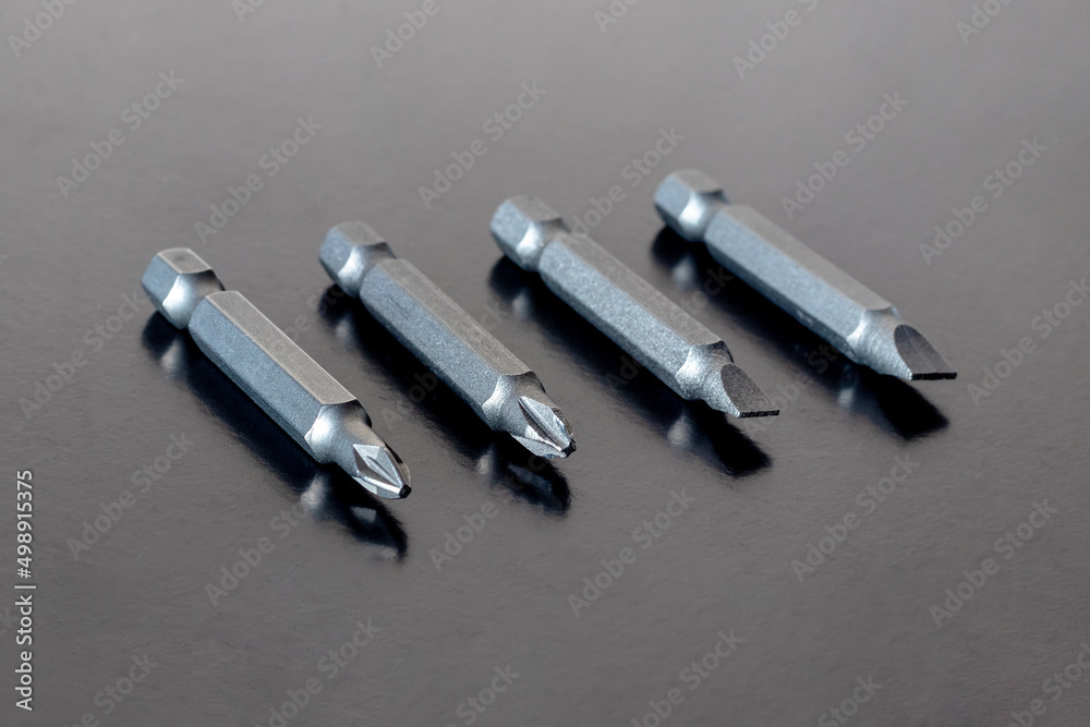 Bits, nozzles for tightening screws on a dark brown background Bits, nozzles for tightening screws on a dark brown background