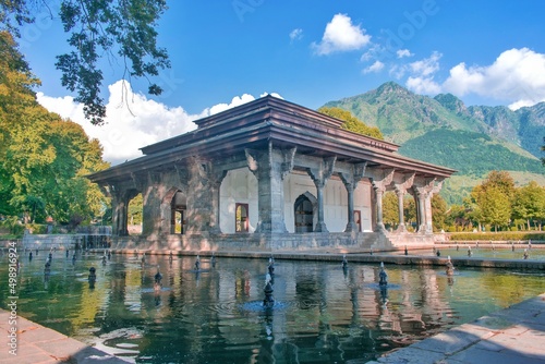 Beautiful picture of a historical monument in world famous Shalimar garden in Srinagar, Kashmir with blue sky, mountains and water bodies around photo