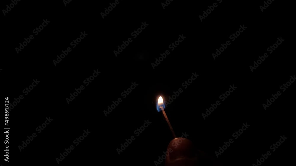The match is lit in the dark on black background. HD slow motion