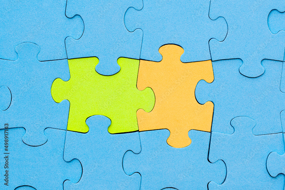 Green and yellow jigsaw puzzle pieces stands out from the crowd Green and yellow jigsaw puzzle pieces stands out from the crowd
