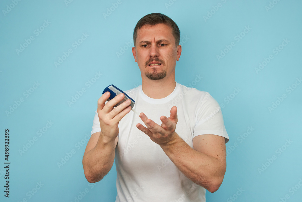 Man checking blood sugar level with glucometer. Man checking blood sugar level with glucometer.