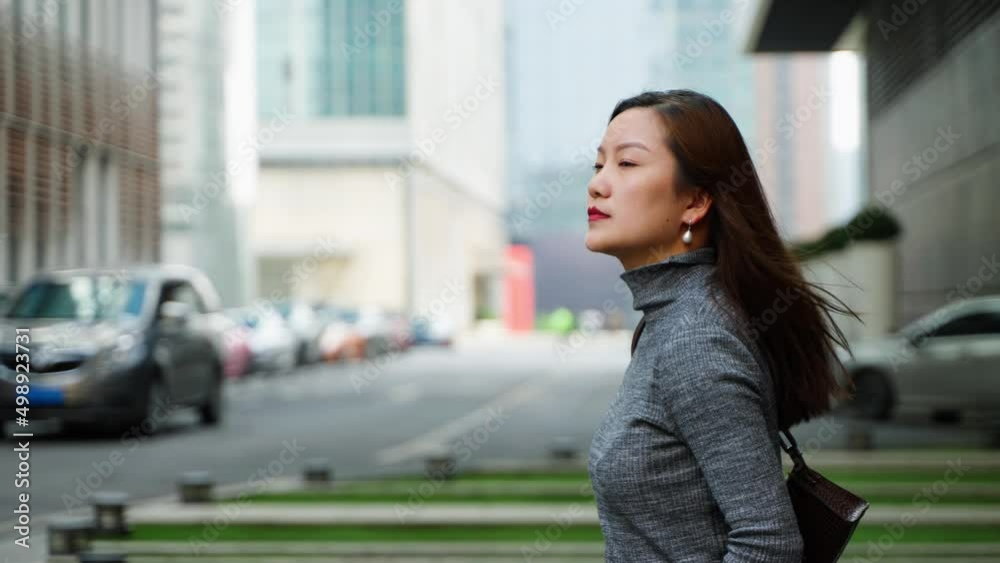Charming young asian business woman walking in the city side view slow motion clip