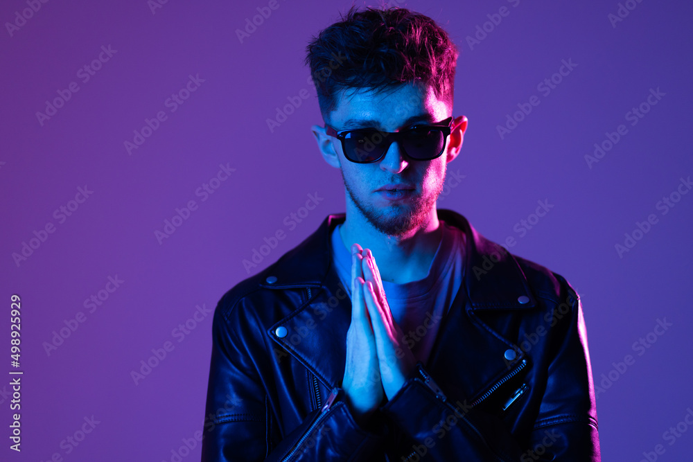 Neon light studio portrait of serious man model with mustaches and beard in sunglasses Neon light studio portrait of serious man model with mustaches and beard in sunglasses