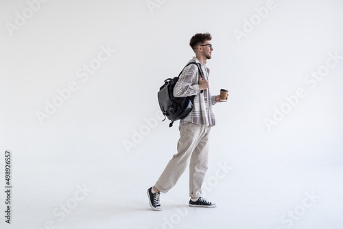 Young man wearing bag walking isolated on white background