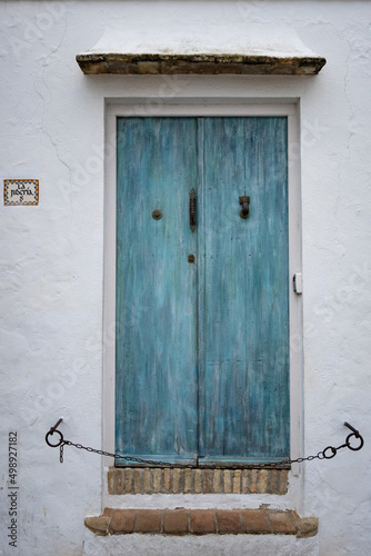 Blue turquoise wooden door at a typical white village house in Andalusia, south Spain