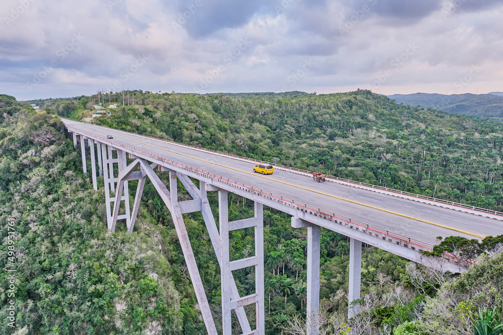 The highest of Cuba Bacunayagua Bridge. Automobile and horse-drawn transport moving along bridge.