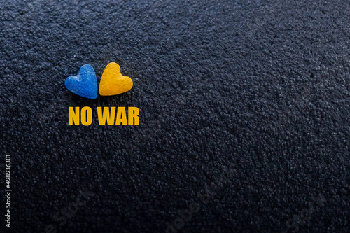 Text: Peace. Solidarity With Ukraine Abstract black Background with with a yellow and blue hearts, Ukrainian Flag. Russia's invasion of Ukraine. War.