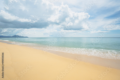 Sea golden sand clear beach sunny.  blue sky white clouds daytime. Waves water smoothly shore side. 