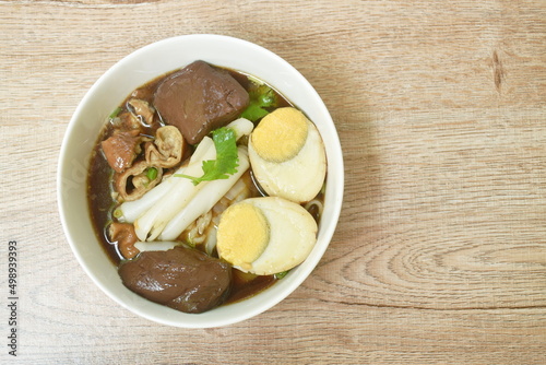 Chinese rice flour paste with pork and entrails topping egg yolk in soup on bowl