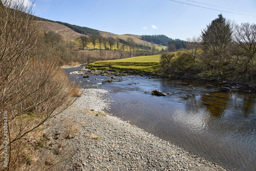 A sunny view downstream of the River Esk from the bridge at Bentpath