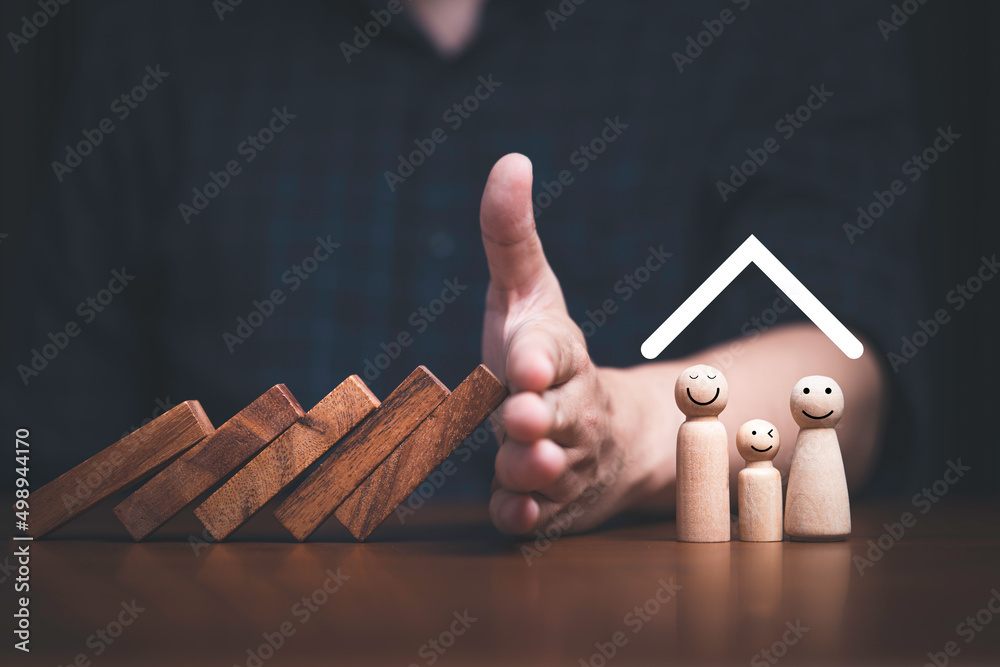 Businessman hand stop wooden block falling to protect family for assurance life and asset concept. - obrazy, fototapety, plakaty 