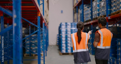Shot from the back of Warehouse workers discussing shipping schedule. Logistic and business export concept.