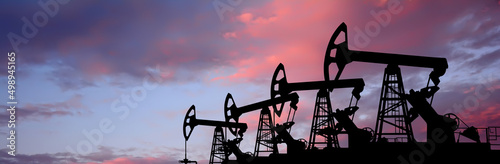 Pump- jacks on sunset background. Oil production