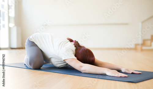 pregnant woman is engaged in yoga. Children asana with knees apart or Balasana
