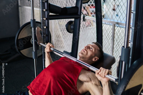 A man lifting weights on a bench press. 