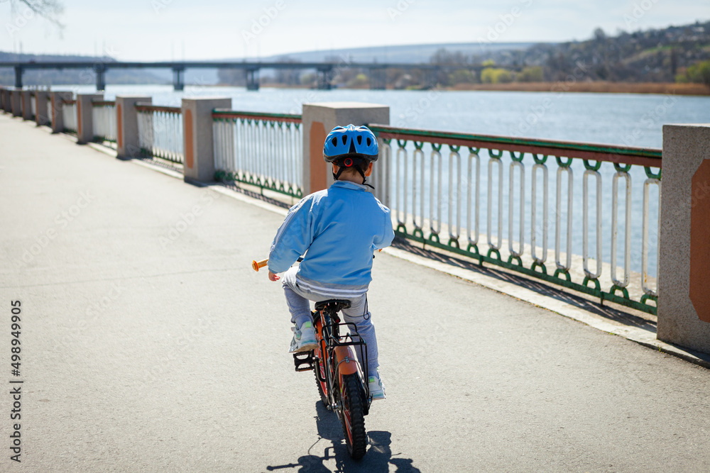 Obraz premium boy on a bicycle in a blue jacket and helmet 