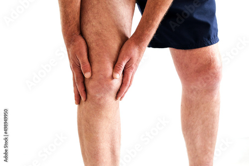 Canvas Print a man got injured holding on knee because of pain from overuse knee or workout isolated on white, copy space for text