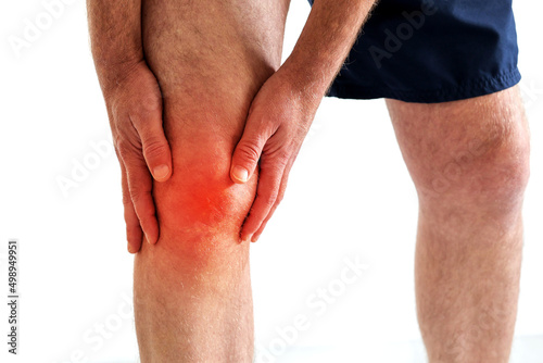a man got injured holding on knee because of pain from overuse knee or workout, explain hurt area with red gradient color isolated on white, copy space for text. Injury from workout concept 