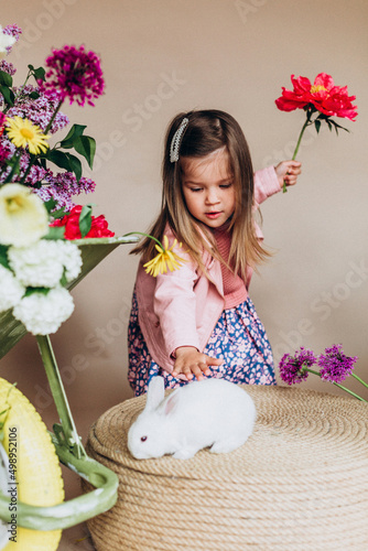 Noise effect, Cute preschool girl with spring flowers, garden tools and animals. Easter mood and real colorful flowers