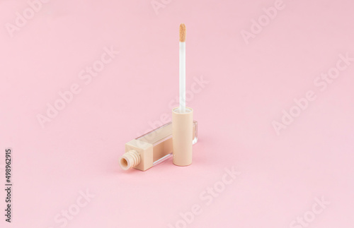 фотографія Cream concealer for correcting facial imperfections with an applicator on a pink
