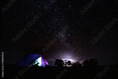 Cicloviajante acampando com céu estrelado