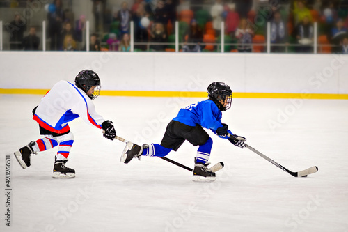 Children playing hockey on the ice arena