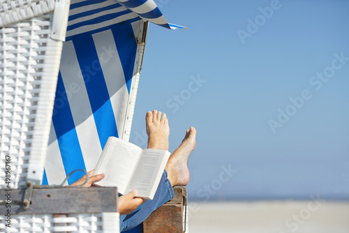 Fototapeta Naklejka Na Ścianę i Meble -  reading a book in beach chair in summer vacation