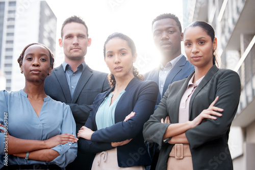 We strive for corporate excellence. Shot of a group of young businesspeople standing with their arms crossed against a city background.