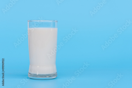 World Milk Day, A glass of white milk isolated on a blue background, close up. Happy Milk Day. Dairy product concept, copy space on right for design or content, nobody, World Milk Day 1 June