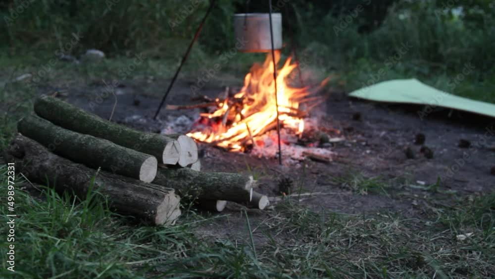 Campfire burns in a middle of a camp Campfire burns in a middle of a camp