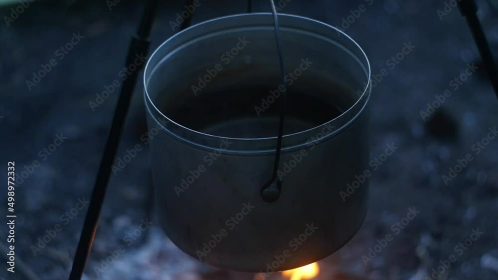 Middle frame of pan with water over the fire on a tripod Middle frame of pan with water over the fire on a tripod