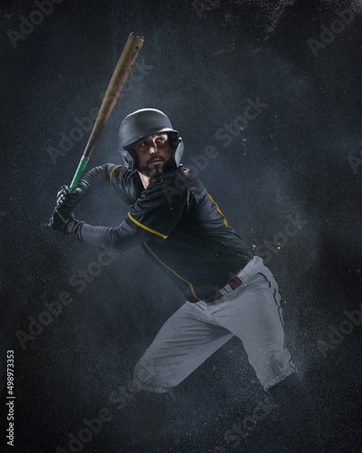 Photography Creative portrait of professional baseball player in sports equipment getting ready to hit isolated on smoked background