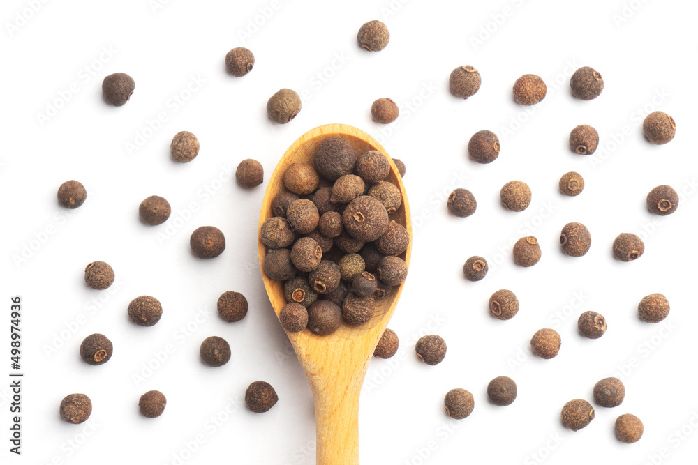 Spice Allspice in wooden spoon and bunch on white background isolated. Flat lay. Macro. Healthy eating concept