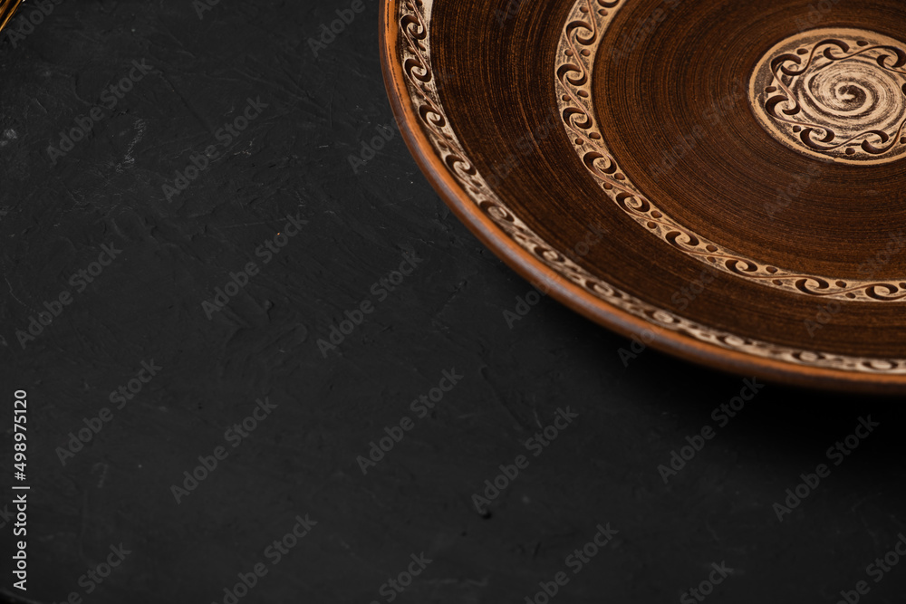 Ancient clay plate on a black background Ancient clay plate on a black background