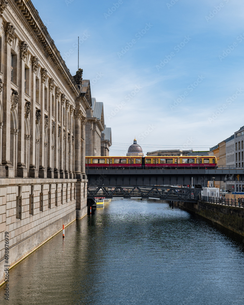 Berlin, Germany: S-Bahn train passing by on the bridge of Museum Island. The building of Humboldt Forum on the background