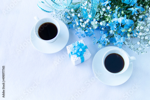 コーヒーとプレゼントと青いリボンとデルフィニウムとカスミソウの花束 