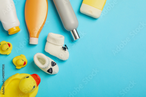 Flat lay composition with baby cosmetic products on light blue background  space for text